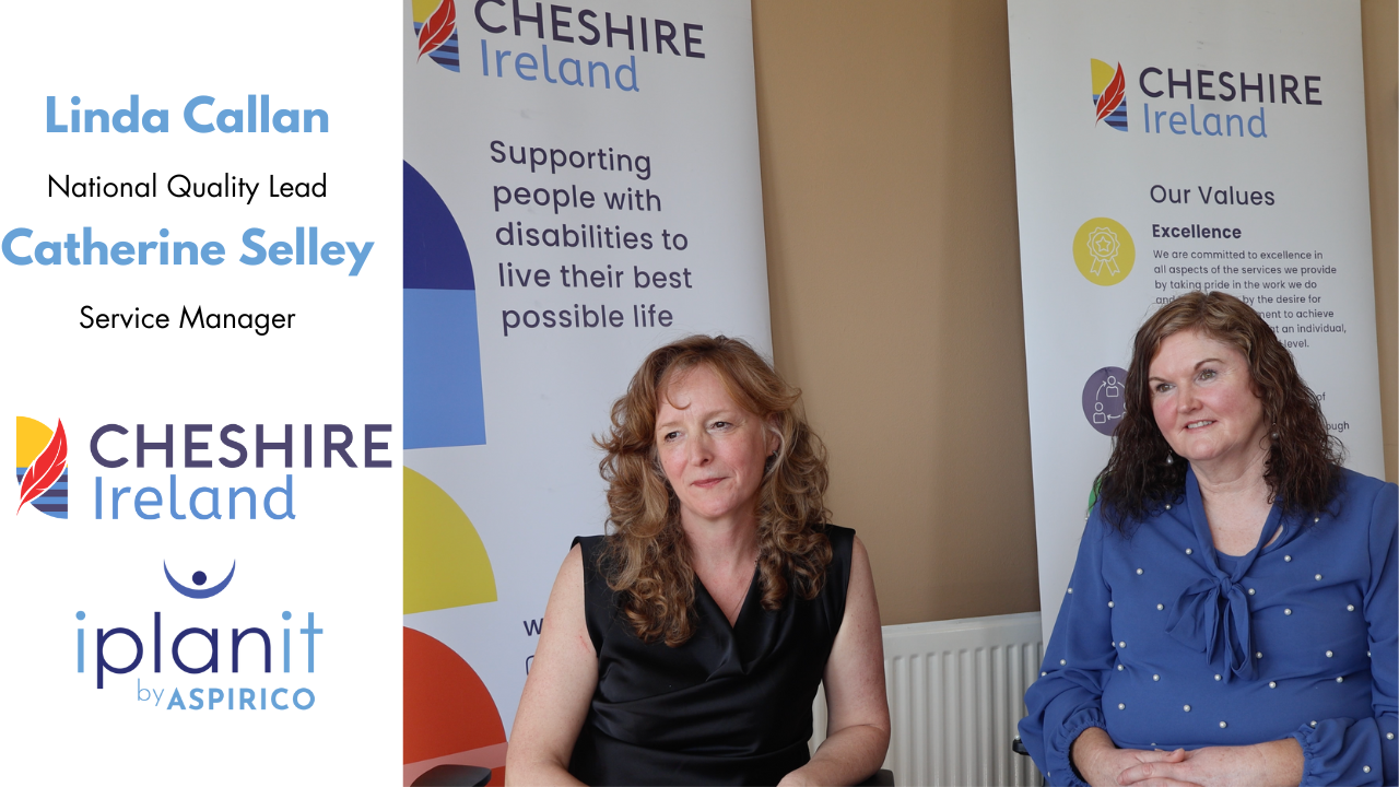 Two women sit in front of banners for Cheshire Ireland, featuring organization values and logos for Cheshire Ireland and iPlanit by Aspirico.